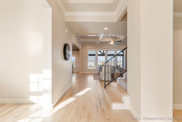 hall featuring coffered ceiling, wood finished floors, ornamental molding, beamed ceiling, and stairs
