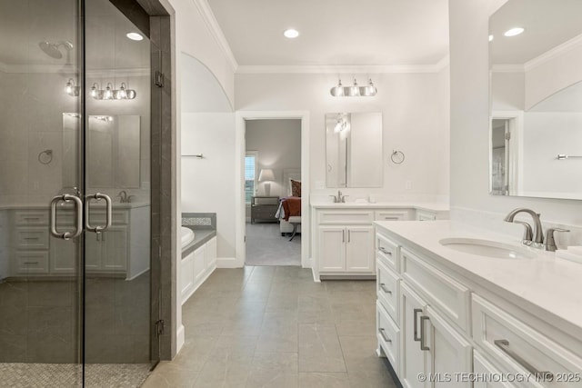 ensuite bathroom with a sink, a shower stall, and ornamental molding