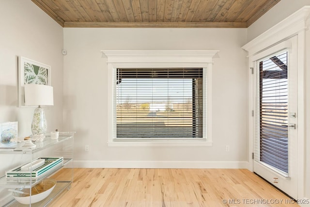 interior space featuring baseboards, crown molding, and wood finished floors