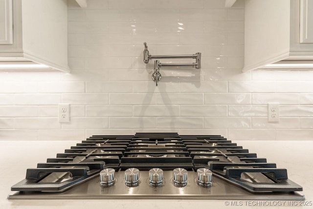details with stainless steel gas stovetop and backsplash