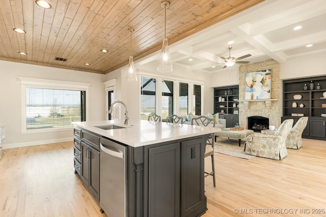 kitchen with recessed lighting, light countertops, stainless steel dishwasher, a sink, and light wood-style flooring