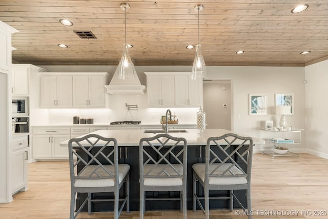 kitchen with wooden ceiling, a sink, wall oven, and light wood-style floors