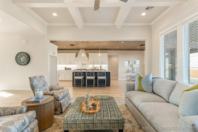 living area featuring visible vents, beamed ceiling, light wood finished floors, and recessed lighting