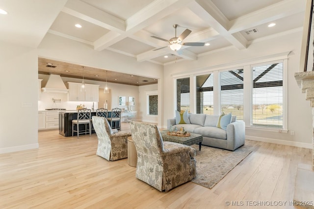 living room featuring beam ceiling, visible vents, a wealth of natural light, and a ceiling fan