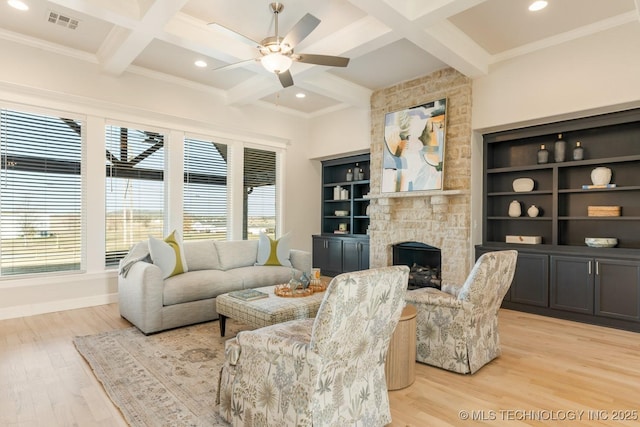 living room featuring visible vents, a stone fireplace, a healthy amount of sunlight, and coffered ceiling