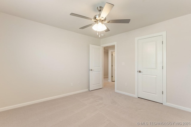unfurnished bedroom featuring light colored carpet, baseboards, and a ceiling fan