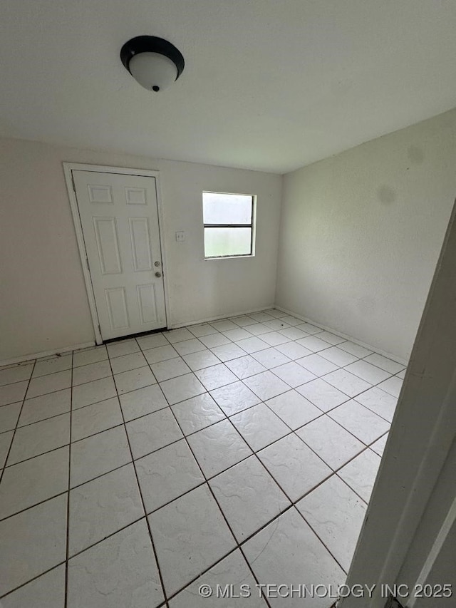 unfurnished room with light tile patterned flooring