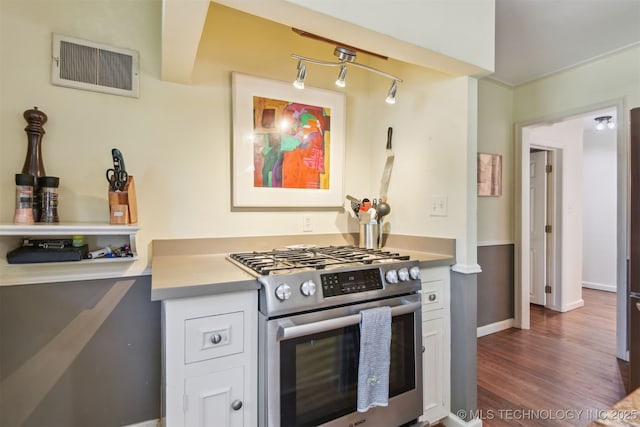 2412 E 23rd St, Tulsa, OK 74114 - kitchen with light countertops, dark wood finished floors, white cabinetry, gas stove, and visible vents