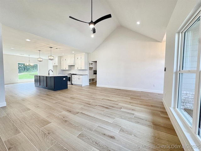574 Woodlands Dr, Tahlequah, OK 74464 - kitchen with open floor plan, stainless steel range with gas cooktop, a sink, white cabinets, and an island with sink