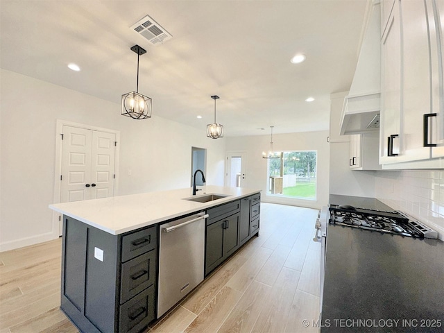 574 Woodlands Dr, Tahlequah, OK 74464 - kitchen with a sink, appliances with stainless steel finishes, white cabinets, custom range hood, and light wood-type flooring