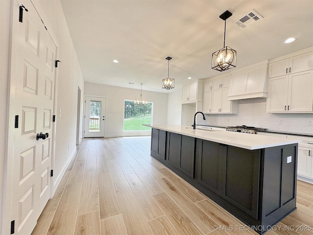 574 Woodlands Dr, Tahlequah, OK 74464 - kitchen featuring a chandelier, custom exhaust hood, white cabinets, a sink, and recessed lighting