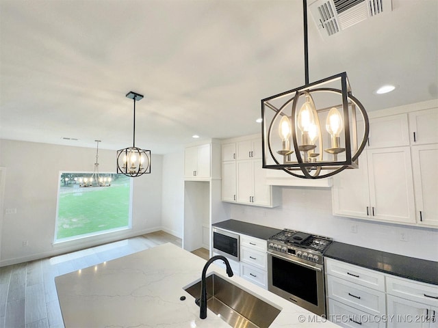 574 Woodlands Dr, Tahlequah, OK 74464 - kitchen featuring a chandelier, stainless steel appliances, a sink, white cabinets, and baseboards