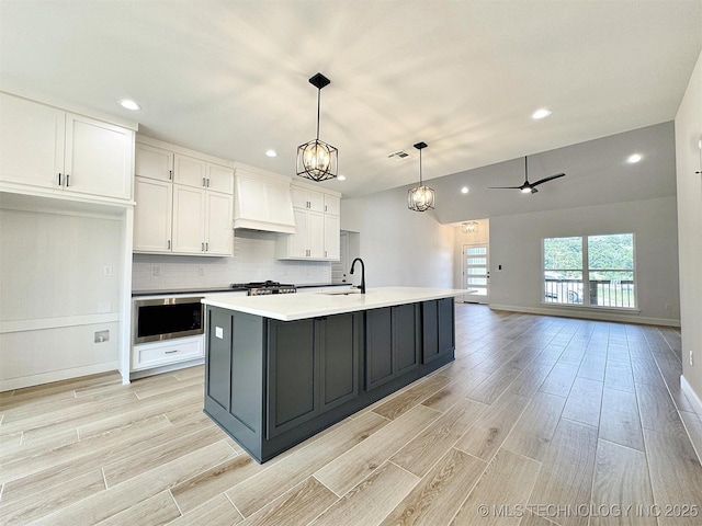 574 Woodlands Dr, Tahlequah, OK 74464 - kitchen featuring custom exhaust hood, light wood-type flooring, white cabinets, light countertops, and recessed lighting