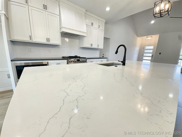 574 Woodlands Dr, Tahlequah, OK 74464 - kitchen featuring a sink, stainless steel stove, tasteful backsplash, custom exhaust hood, and light stone counters