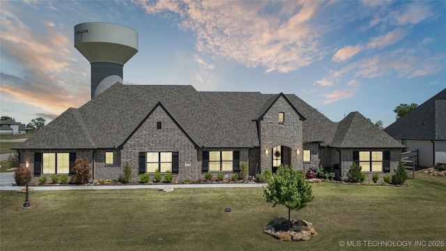 19340 E Canyon Ridge Rd, Owasso, OK 74055 - french country style house with a shingled roof, brick siding, and a front yard