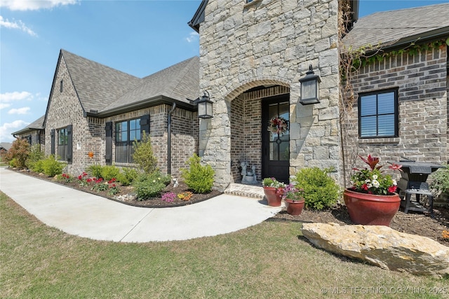 19340 E Canyon Ridge Rd, Owasso, OK 74055 - view of exterior entry featuring brick siding, roof with shingles, and stone siding