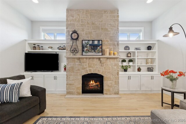 19340 E Canyon Ridge Rd, Owasso, OK 74055 - living room featuring a wealth of natural light, a stone fireplace, and light wood-type flooring