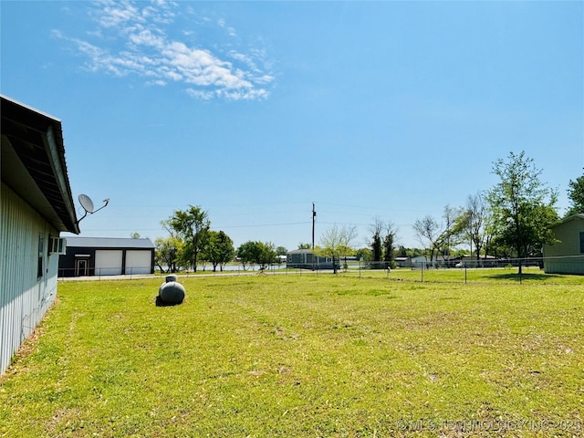 view of yard with a detached garage and fence