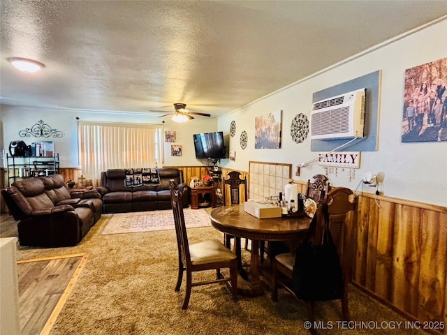 dining space featuring wainscoting, ceiling fan, a textured ceiling, and a wall mounted AC