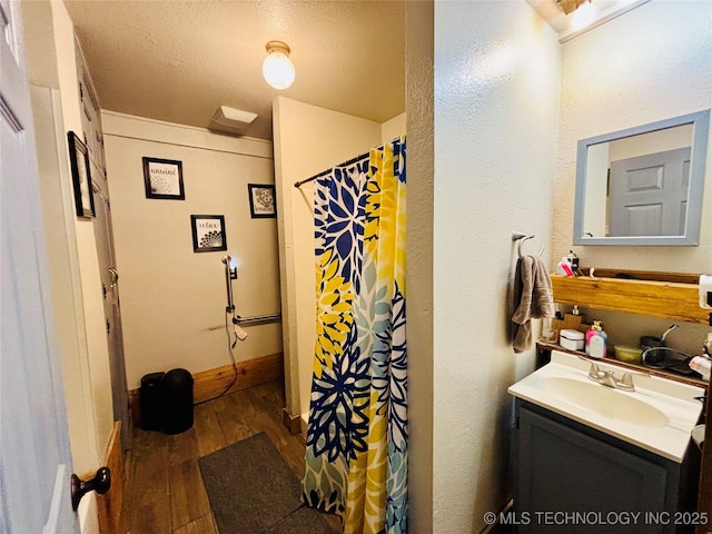 bathroom featuring wood-type flooring, a textured ceiling, vanity, and a shower with curtain