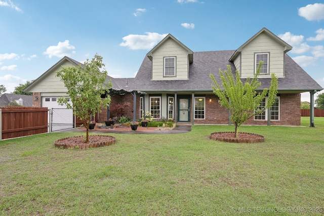 cape cod house featuring a front yard, roof with shingles, a garage, brick siding, and fence