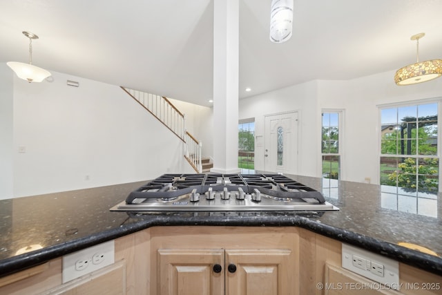 kitchen featuring stainless steel gas cooktop, light brown cabinetry, decorative light fixtures, and a wealth of natural light