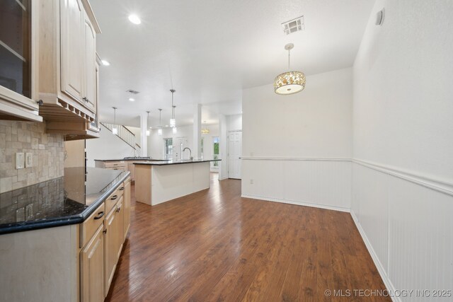 kitchen with visible vents, dark wood finished floors, backsplash, and a wainscoted wall
