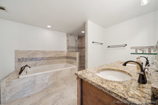 bathroom featuring vanity, a tile shower, a bath, and visible vents