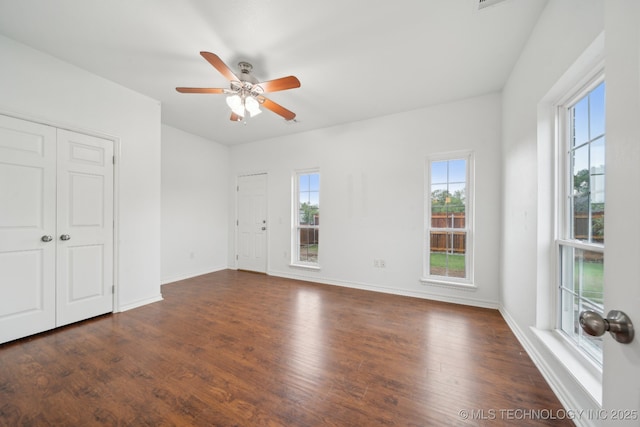 interior space with dark wood-type flooring, baseboards, and ceiling fan