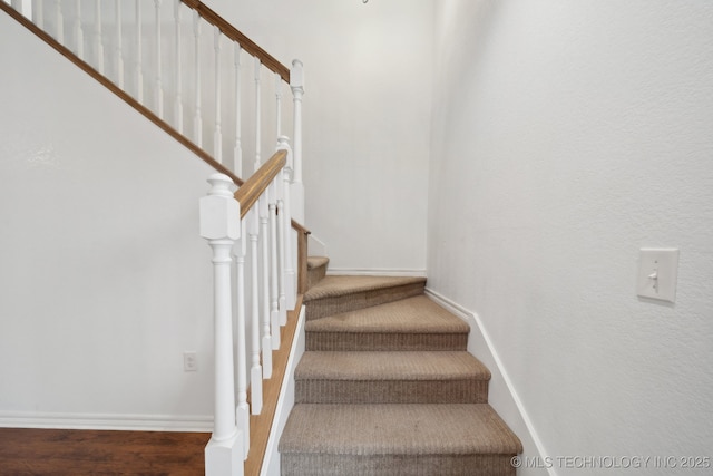 stairway featuring baseboards and wood finished floors