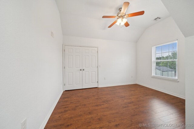 unfurnished room featuring a ceiling fan, visible vents, wood finished floors, and vaulted ceiling