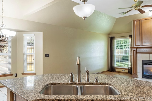 3701 Bridgeport Rd, Norman, OK 73072 - kitchen with a fireplace, stone counters, ceiling fan, lofted ceiling, and pendant lighting