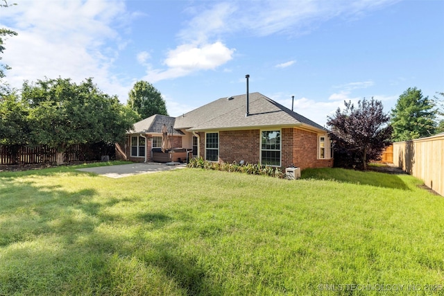 3701 Bridgeport Rd, Norman, OK 73072 - rear view of property featuring a hot tub, a patio, a fenced backyard, brick siding, and a shingled roof