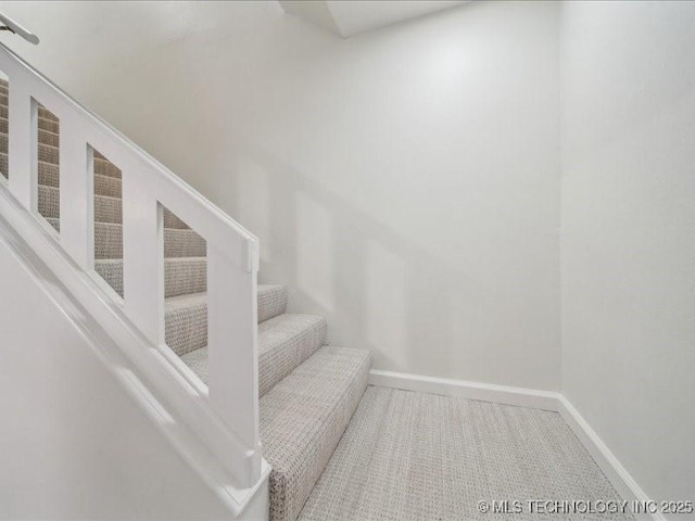 stairway with carpet floors and baseboards