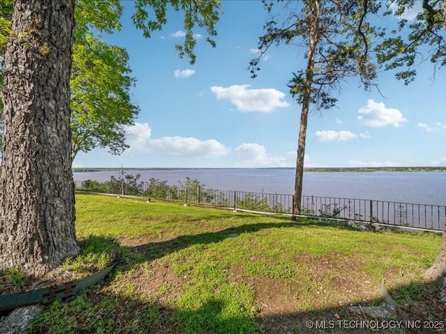 exterior space with fence and a water view