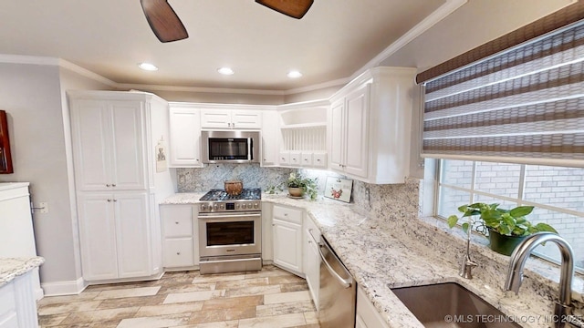 kitchen featuring a sink, white cabinetry, backsplash, and stainless steel appliances
