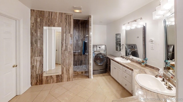 full bath with a sink, washer / dryer, and tile patterned floors