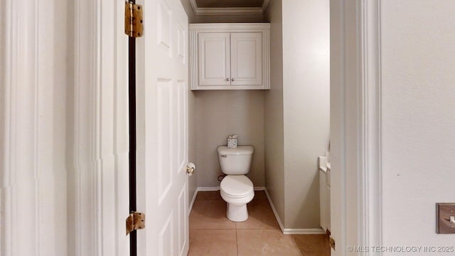 bathroom with crown molding, tile patterned floors, baseboards, and toilet
