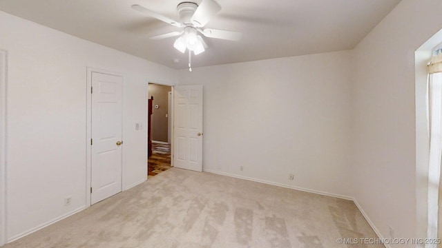 unfurnished bedroom featuring baseboards, ceiling fan, and light carpet