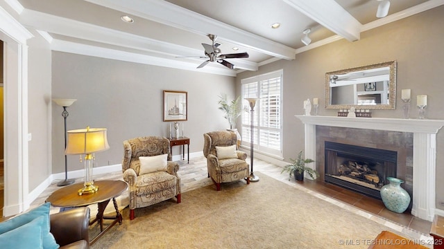 living area featuring crown molding, a fireplace, beamed ceiling, ceiling fan, and recessed lighting