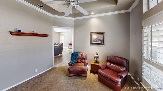 sitting room featuring baseboards, ornamental molding, ceiling fan, and a healthy amount of sunlight