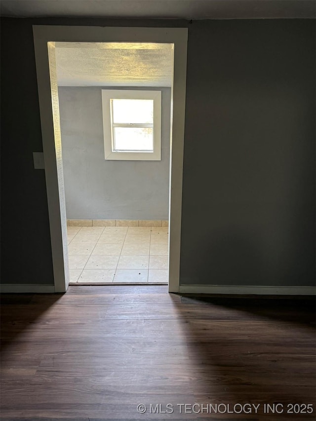 unfurnished room featuring wood finished floors and baseboards