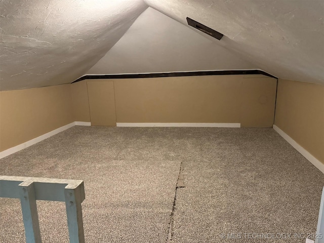 bonus room featuring carpet, a textured ceiling, lofted ceiling, and baseboards