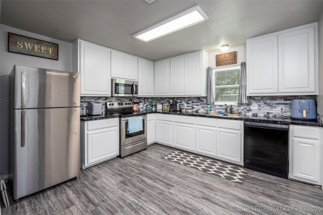 647 Sawmill Rd, Durant, OK 74701 - kitchen featuring white cabinets, wood finished floors, backsplash, and appliances with stainless steel finishes