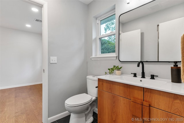 bathroom with visible vents, vanity, toilet, baseboards, and recessed lighting