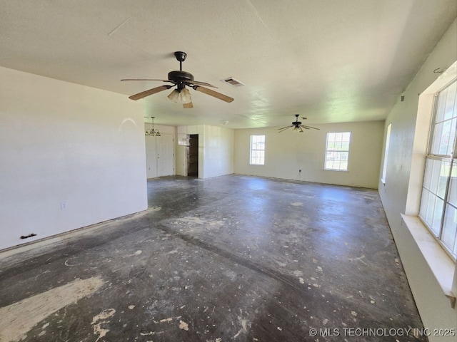 spare room featuring ceiling fan, visible vents, and unfinished concrete floors