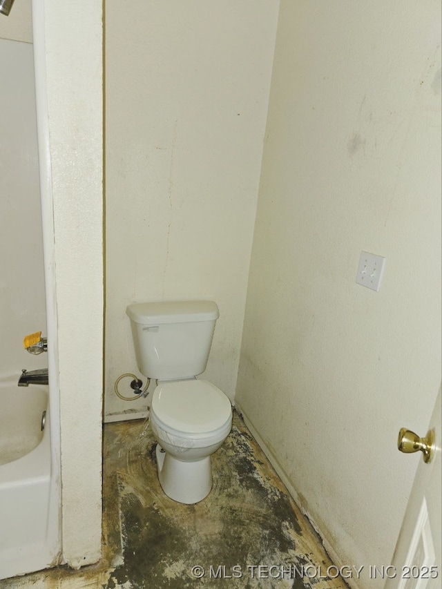 bathroom featuring toilet and a tub