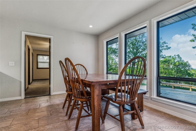dining room with baseboards, recessed lighting, and stone finish flooring
