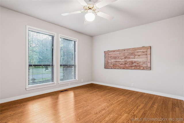 unfurnished room featuring visible vents, baseboards, a ceiling fan, and wood finished floors