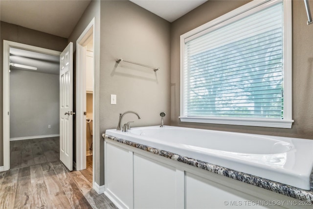 21083 Stick Ross Mountain Rd, Tahlequah, OK 74464 - full bathroom featuring wood finished floors, a garden tub, and baseboards